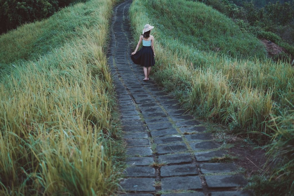 Woman walking along a peaceful path as part of a beginner weight loss routine