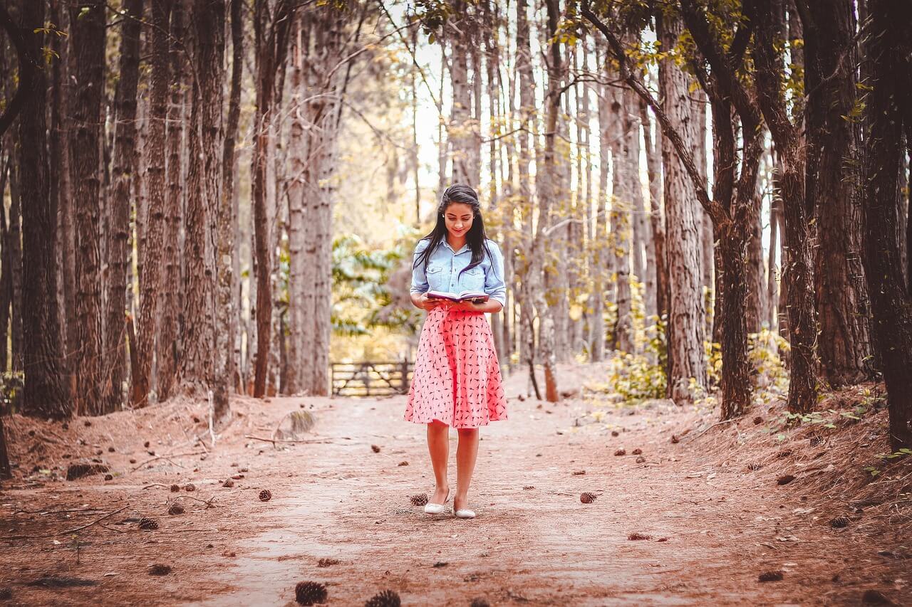 Woman walking alone on a forest path as part of a daily walking routine