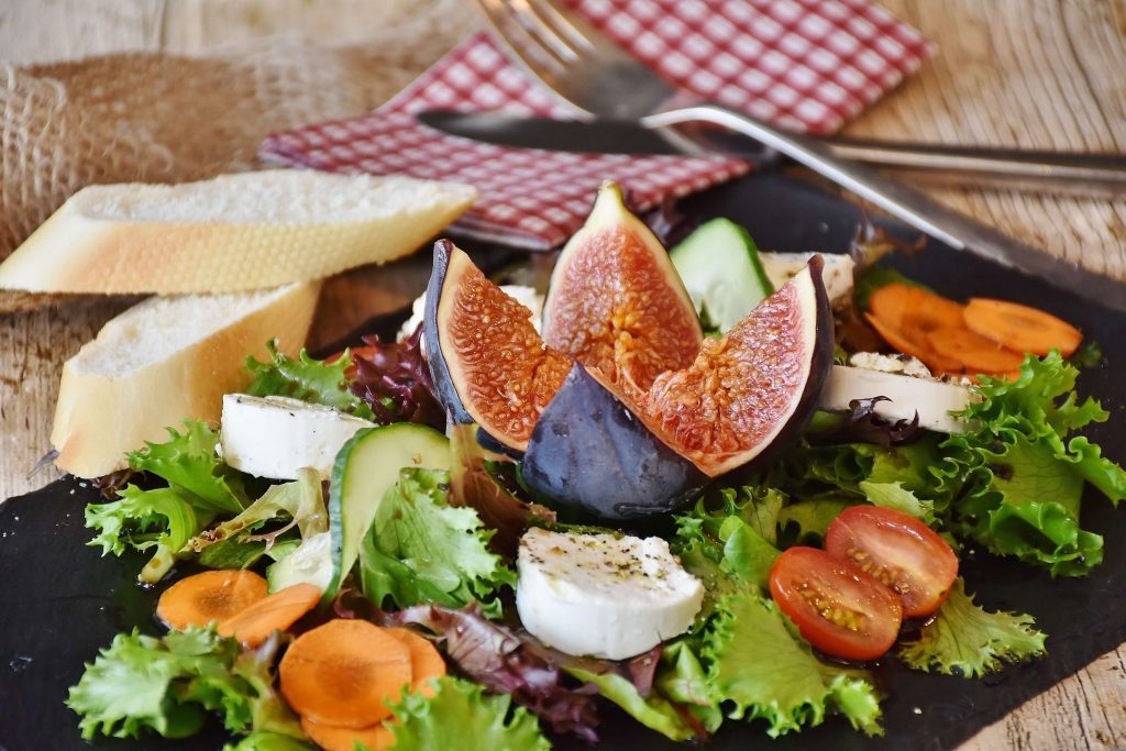 Healthy breakfast after a morning walk with fresh vegetables, cheese, and figs