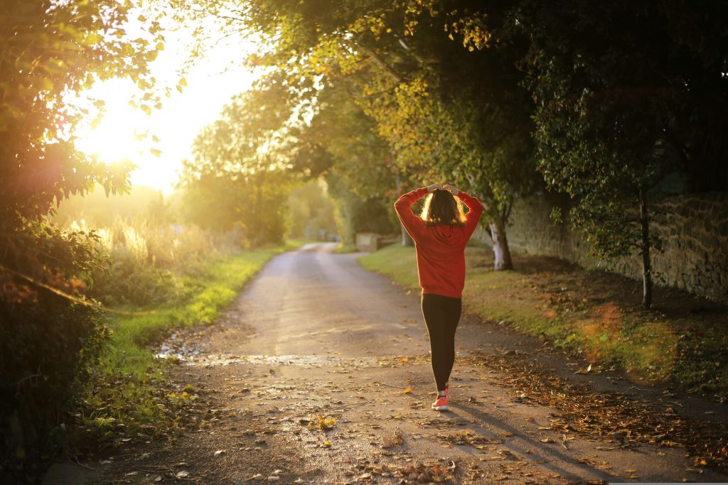 Woman fast walking on a quiet road during sunrise for weight loss and better health