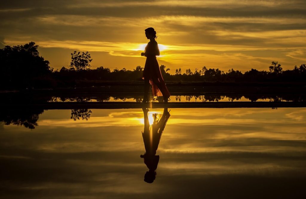 Silhouette of a person walking at sunset showing evening walk benefits