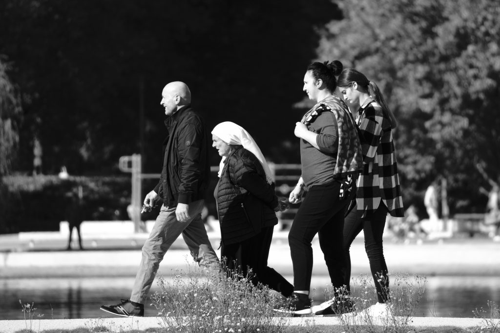 A group of seniors walking outdoors in a park for heart health and brain protection