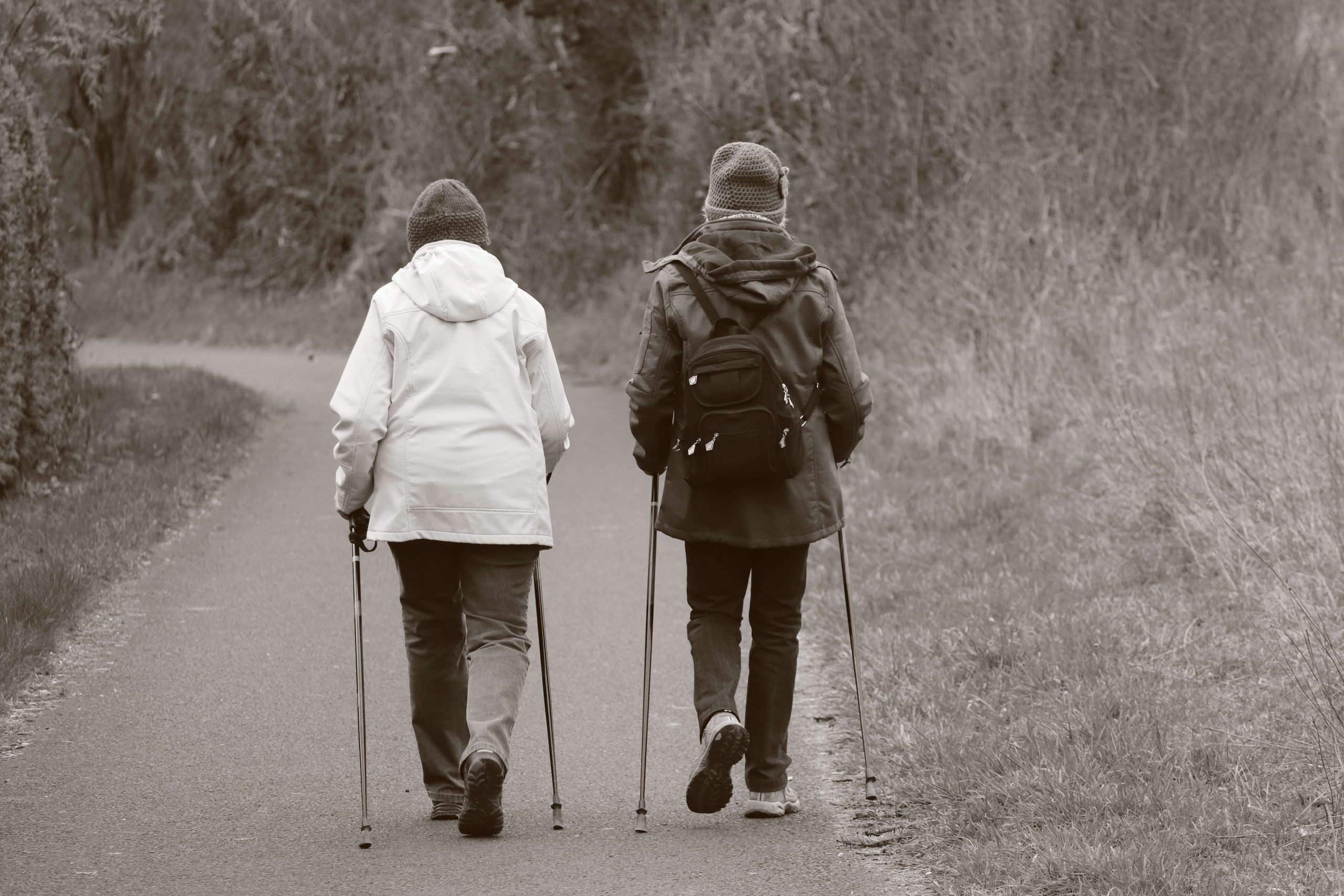 Two elderly people walking with nordic poles to manage arthritis pain