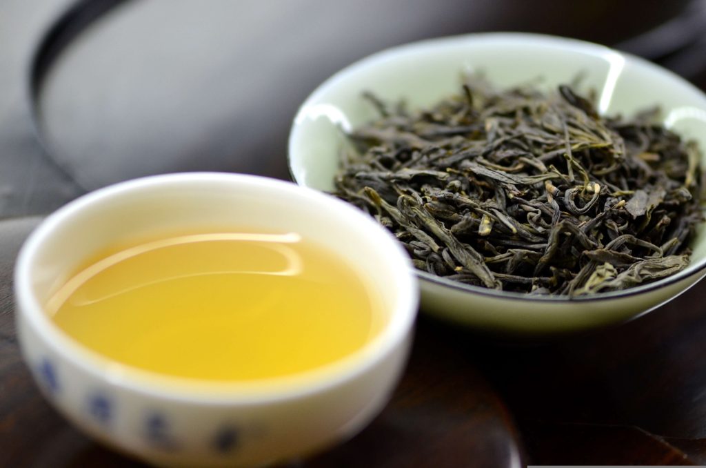 Green tea and dried tea leaves, a healthy beverage choice among foods that help reduce inflammation naturally